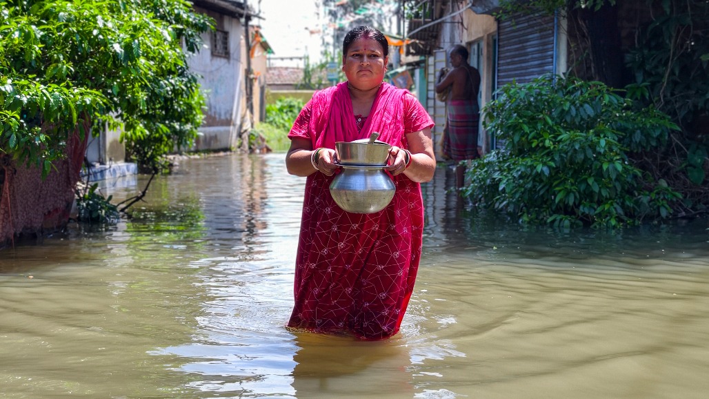8-West Bengal-Haldia--- A woman carries cooked food from a relief camp while wading through accumulated floodwater in Chiranjipur, Haldia, West Bengal,.jpg
