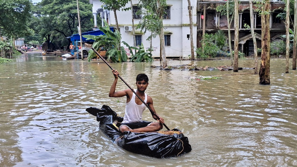 3-West Bengal-Paschim Medinipur--- A man travels on a makeshift boat along a flood-submerged road in Laro village of Sabang Block in Paschim Medinipur district of West Bengal.jpg