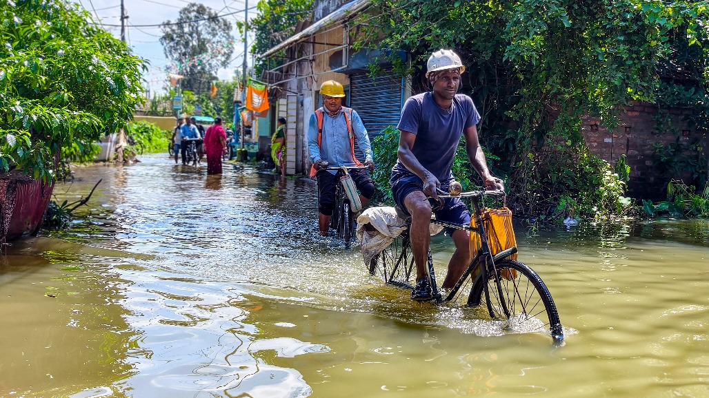4-West Bengal-Haldia--- Workers wade through a waterlogged area as they make their way to factories for work in Haldia, West Bengal,.jpg
