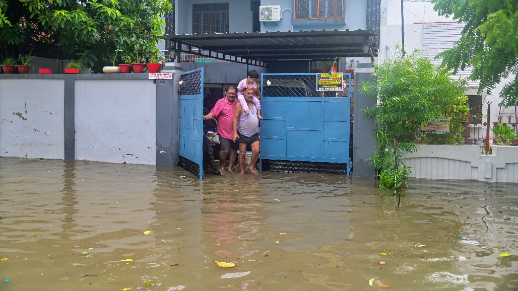 10-Uttar Pradesh-Prayagraj--- Residents step out of a house through a waterlogged area after heavy rain in Prayagraj, Uttar Pradesh,.jpg